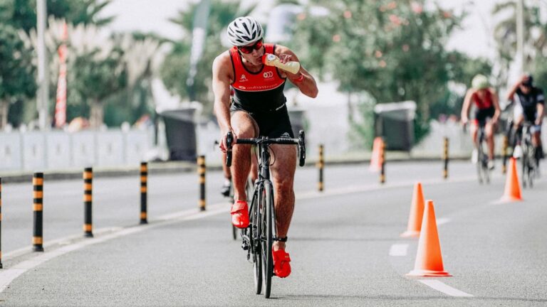 Cyclist riding during training while drinking water to maintain hydration and performance