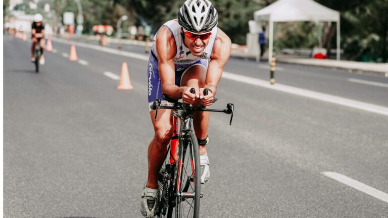 Triathlete cycling on open road with smooth cadence, focusing on low-intensity Zone 2 training