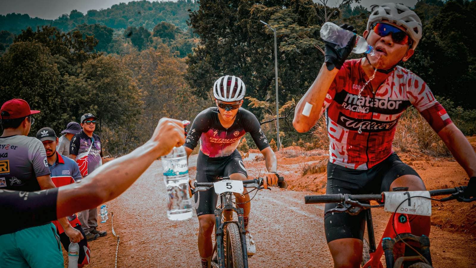 Cyclist drinking water while riding, demonstrating hydration and fueling strategies for long-distance cycling rides