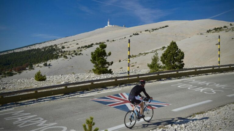 Cyclist cornering downhill on a road bike with proper braking and body positioning