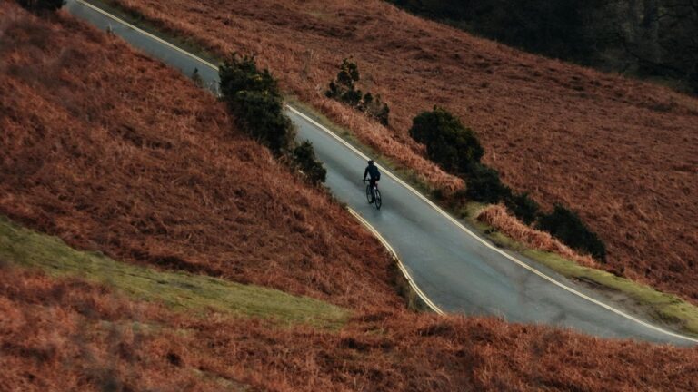Cyclist shifting to lower gear while climbing uphill to maintain rhythm and reduce effort