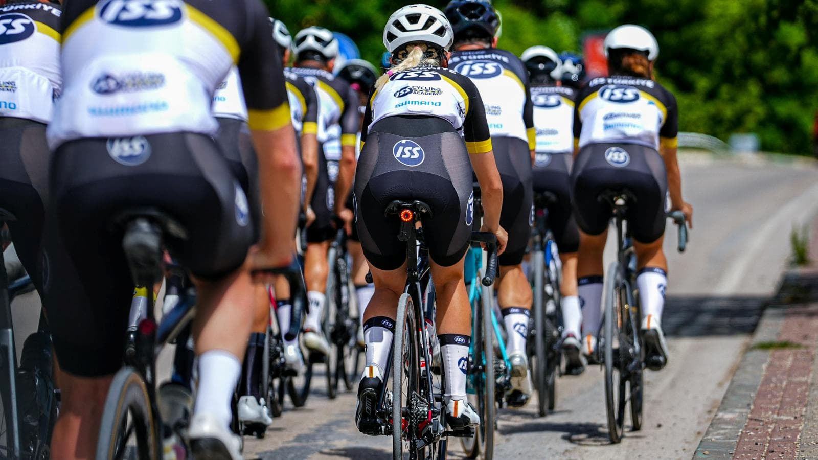 group of cyclists riding together on road maintaining safe distance and proper formation