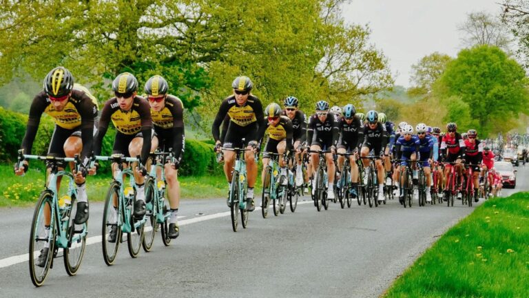 cyclists using hand signals and communication while riding in a group on open road