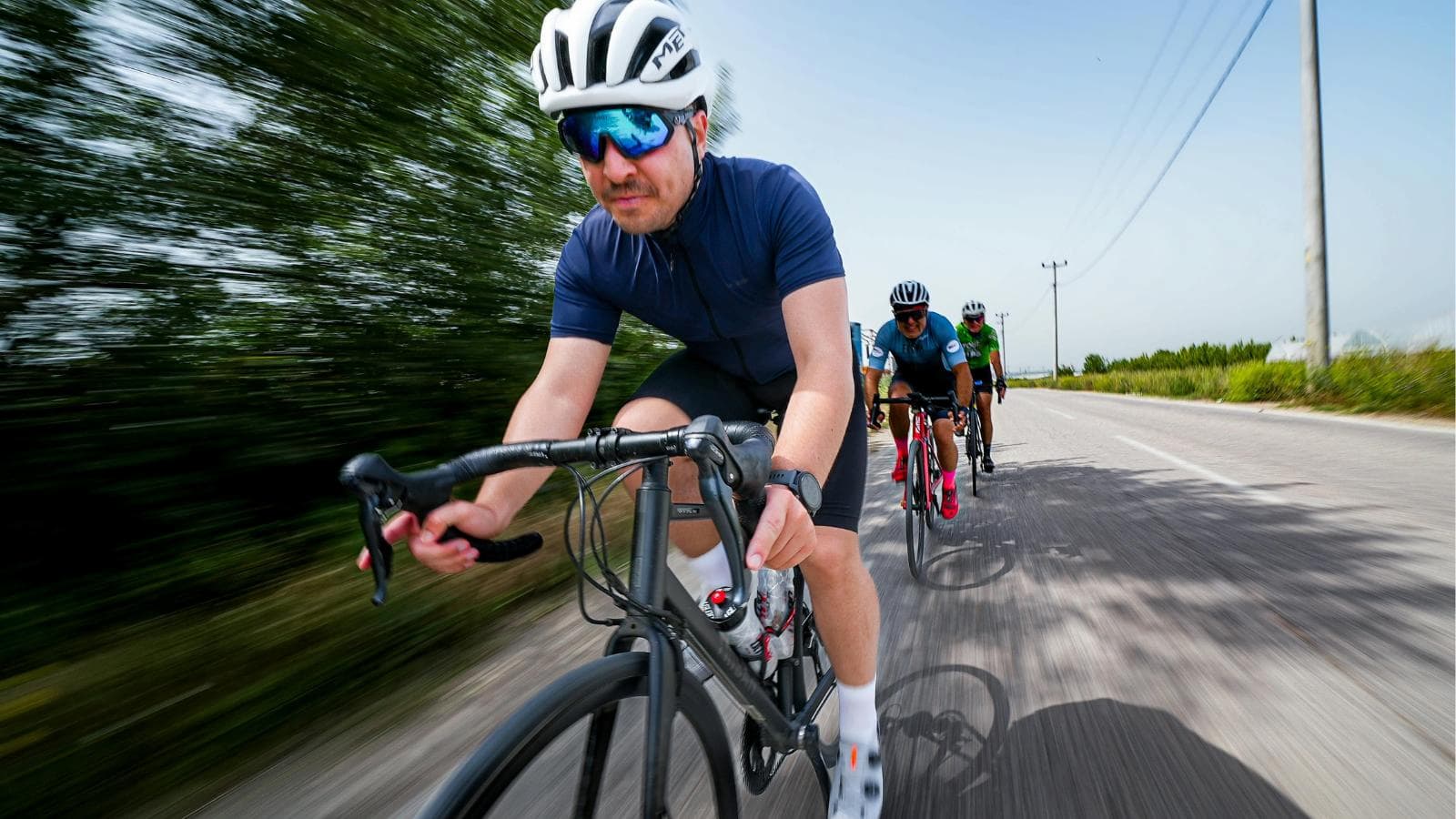 cyclist climbing hill seated on bike maintaining cadence and conserving energy during uphill ride