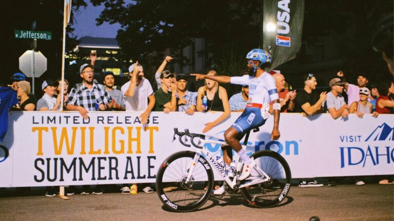 Solo cyclist crossing the finish line in a race, completing their first competitive ride