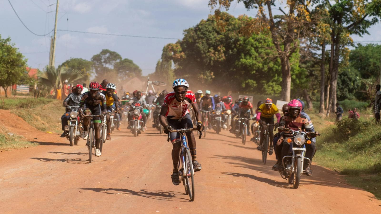 Road cyclist descending fast in aerodynamic position with hands in drops for control