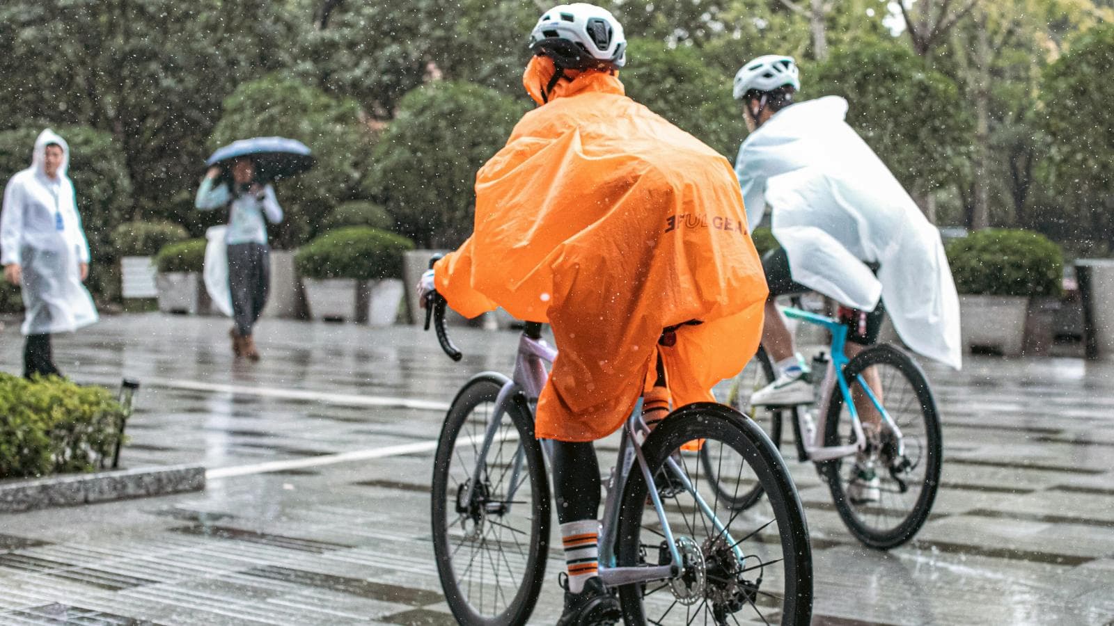 road cyclist using lights and cautious braking while riding in rainy weather conditions