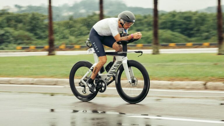cyclist cornering carefully on wet road during rainy cycling training ride