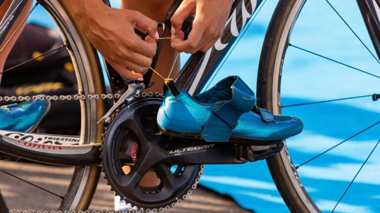 cyclist measuring stack and reach dimensions on road bike frame during professional bike fitting session