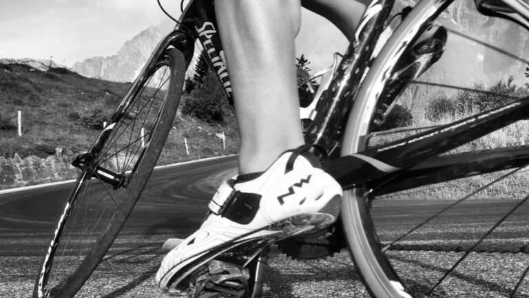 cyclist stretching leg muscles after long bike ride to relieve muscle spasms and improve recovery