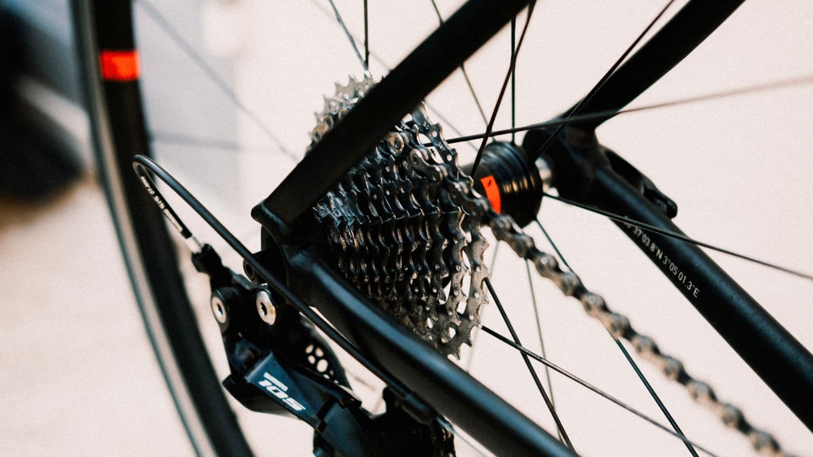 cyclist wiping road bike chain before applying fresh lubricant during bike maintenance