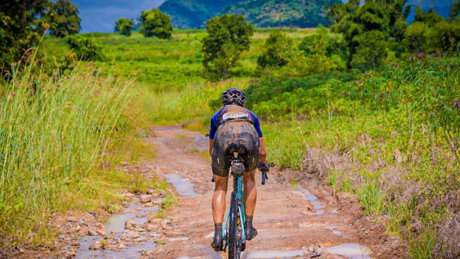 Triathlete confidently cornering through a technical section of a bike course during a training ride.