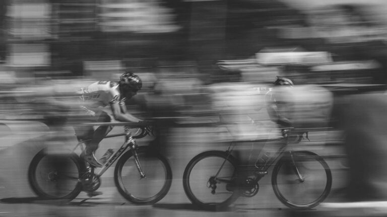 Fatigued road cyclist struggling to maintain speed after starting too hard during a long-distance cycling ride.
