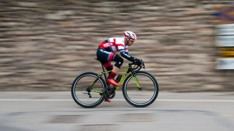 Fatigued cyclist resting beside a road bike after accumulating excessive fatigue from demanding cycling workouts.