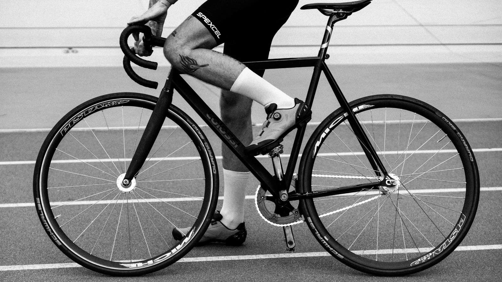 Close-up of a road bike drivetrain showing the chain running at an extreme angle between the front chainring and rear cassette.