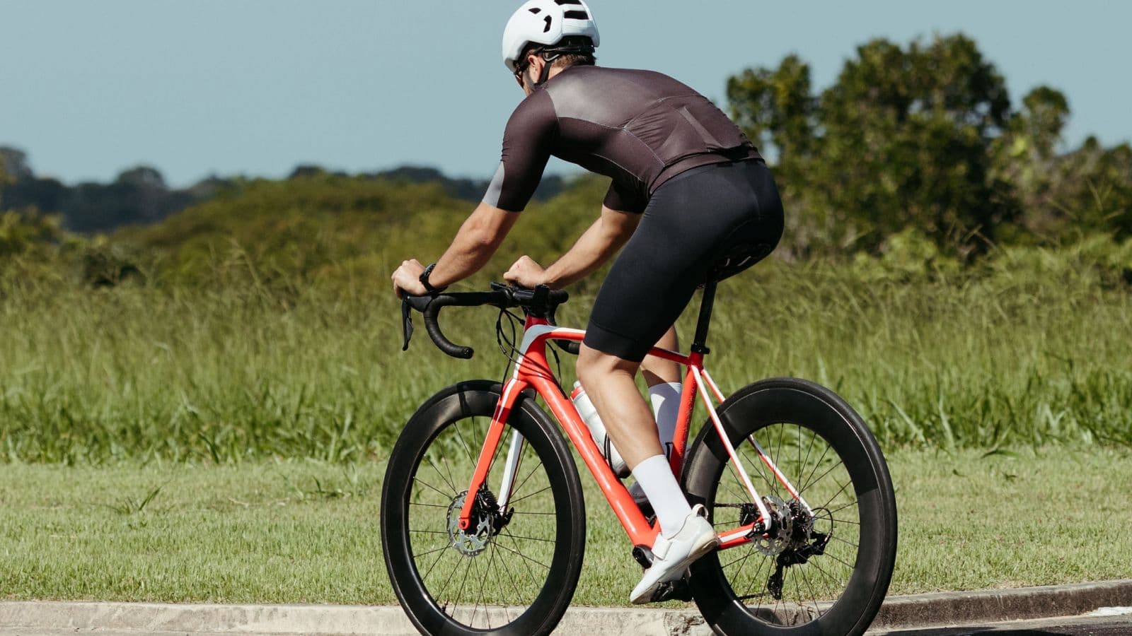 Road cyclist experiencing saddle discomfort during a long cycling training session.