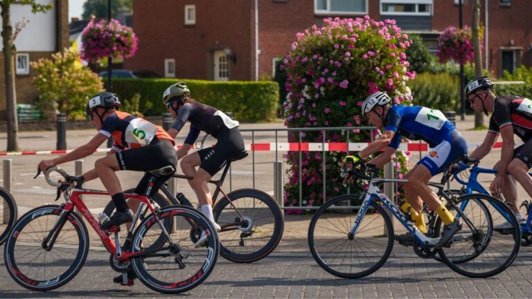 Road cyclists riding closely in a group formation to reduce aerodynamic drag and conserve energy.