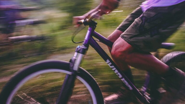 Road cyclist completing a long hill climb during an endurance cycling challenge on a mountainous route.