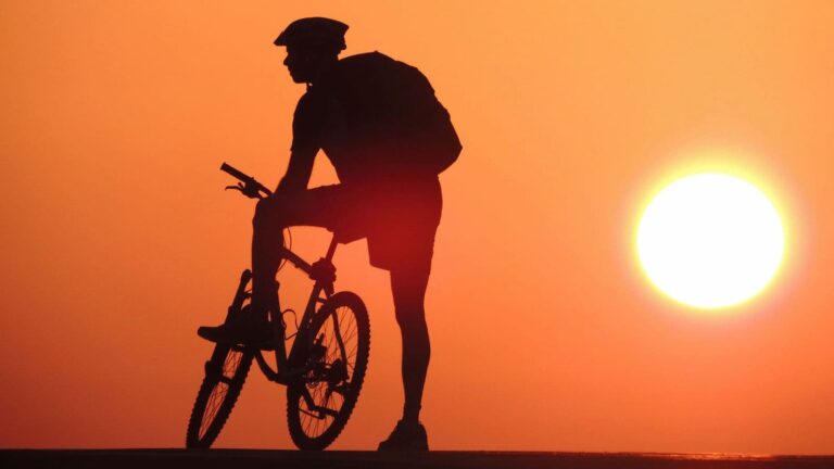 Road cyclist completing an early morning training ride at sunrise while adjusting to the body's natural daily rhythm.